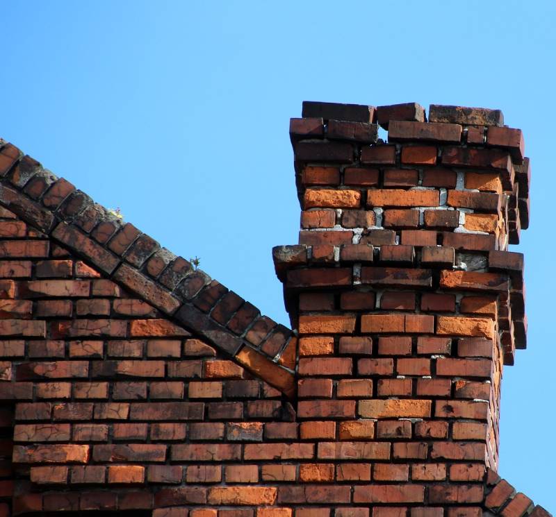 Damaged chimney on an Miami home showing cracks and missing mortar